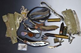 Three Kukri knives, largest blade 30cm, together with two brass shells, military belts and