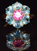 An 18ct gold ring set with a round cut pink tourmaline and six zircons in a cluster setting, size P,