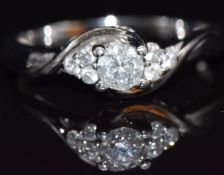 An 18ct white gold ring set with a diamond of approximately 0.3ct with further diamonds to the
