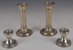 Two pairs of hallmarked silver candlesticks, larger pair Birmingham 1906, maker's mark rubbed,