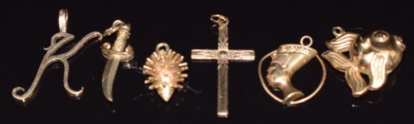 A 9ct gold 'K' pendant, 9ct gold cross, and three 9ct gold charms, 6.5g