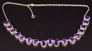 A c1910 9ct gold necklace set with graduated oval mixed cut amethysts, the largest stone