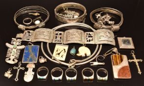 A collection of silver jewellery including bangles, brooch set with emeralds, rings, lapis set