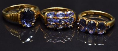 Three 9ct gold rings set with tanzanites and amethysts, size N, 8.5g
