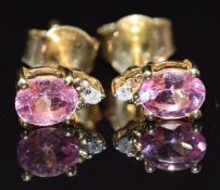 A pair of 10k gold earrings set with an oval pink sapphire and diamond to each, 1.1g