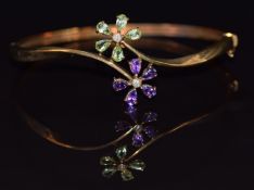 A 9k gold bangle set with amethysts and peridot in two floral clusters, 7.5g