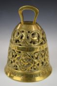 A heavy relief mould and pierced brass bell with figural decoration and Latin script, H19cm