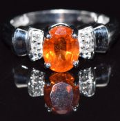 A 9k white gold ring set with an oval cut garnet and diamonds, size M, 3.3g