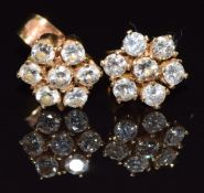 A pair of 18k gold earrings set with diamonds in a cluster, total diamond weight approximately 0.