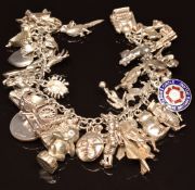 A silver charm bracelet with over 30 silver charms including heart, gun, St Christopher, owl, cat,