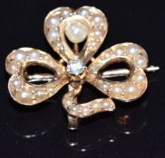 A 14k gold pendant/ brooch in the form of a clover/ shamrock set with seed pearls, pearl and a
