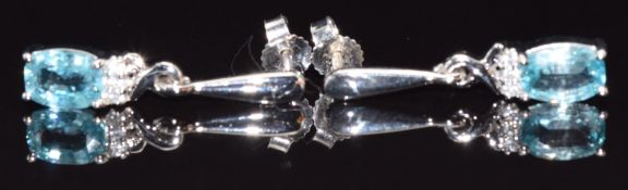 A pair of 9ct white gold earrings set with an oval aquamarine and diamonds to each, 3.1g
