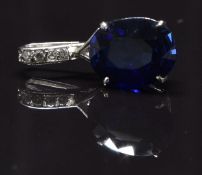 An 18k white gold pendant set with an oval cut synthetic sapphire and paste, 4.4g