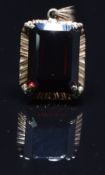 A 14k gold pendant set with an emerald cut garnet, 7.4g