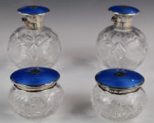 Set of four Asprey hallmarked silver and blue guilloché enamel cut glass dressing table bottles,