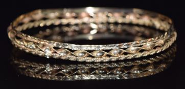 A 9ct gold bangle made up of a twisted bangle, rope twist bangle and a cut out bangle, 10.2g