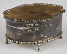 George V hallmarked silver dressing table casket with shaped and engine turned lid, raised on four