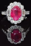An 18ct white gold ring set with an oval cut ruby of approximately 2ct, round cut and baguette cut