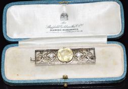 A 1920s Art Deco brooch set with a natural untreated cushion cut yellow Sri Lankan sapphire