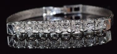 A white gold bracelet set with eight round cut diamonds in a square claw setting, each diamond