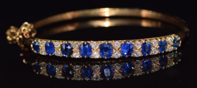 Victorian yellow metal bangle set with 9 cushion cut sapphires and 16 old cut diamonds, 14.5g
