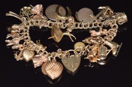 A 9ct gold charm bracelet with over twenty four 9ct gold charms including shamrock, anchor,