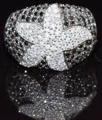 A 9k gold ring set with white and black diamonds in a starfish design, size N, 5.2g