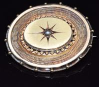 Victorian yellow metal brooch set with a split pearl, verso a glass compartment set with a photo,