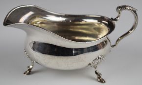George V hallmarked silver sauce or gravy boat with beaded edge and scrolling handle, raised on