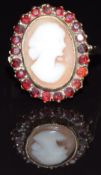 A 9ct gold ring set with a cameo surrounded by garnets, size L, 4.3g