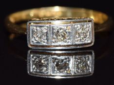 An 18ct gold ring set with three diamonds in a rectangular platinum setting, size M/N, 2.3g
