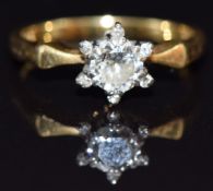 An 18ct gold ring set with a diamond of approximately 0.3ct with six further diamonds to the edge,