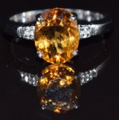 A 9k white gold ring set with an oval cut citrine and diamonds, size N, 3.3g