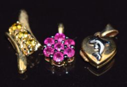 Two 9k gold pendants, one set with garnets the other rubies, and a 9k gold locket, 3g