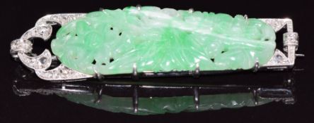 An Art Deco 18ct white gold and platinum brooch set with a carved jadeite plaque and rose cut