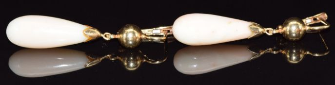 A pair of 18k gold earrings set with coral angel skin coral, 5.5g