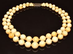 A double strand of c1920 ivory beads with silver clasp, 57g