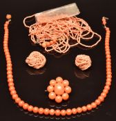 A single strand of coral, a silver gilt brooch set with coral beads, a multi strand angel skin coral