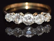 An 18ct gold ring set with five diamonds, the largest approximately 0.25cts, size N/O, 2.3g
