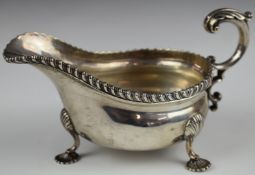 Edward VII hallmarked silver sauce boat with gadrooned edge and raised on three pad feet,