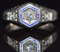 Art Deco ring set with a round cut diamond in an octangonal setting with a baguette cut diamond to