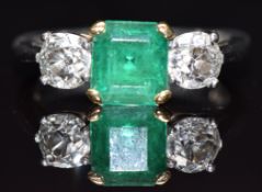 A platinum ring set with an emerald cut emerald of approximately 1.75cts flanked by old cut