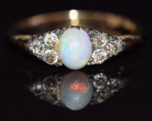A c1920 18ct gold ring set with an opal cabochon and three diamonds to each shoulder, size L, 2.3g