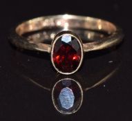 A 9ct gold ring set with an oval cut garnet, size L/M, 1.8g