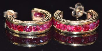 A pair of 9ct gold earrings set with round cut rubies, 6g