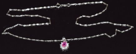 An 18ct white gold necklace with an 18ct white gold pendant set with an oval pink sapphire