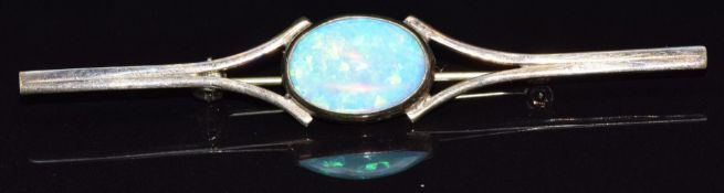 A yellow metal brooch set with an oval synthetic opal cabochon