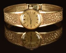 Omega 9ct gold ladies wristwatch with black hands, two-tone baton hour markers, gold dial and signed