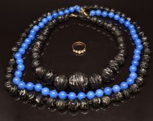 Two carved jet beaded necklaces, a glass beaded necklace and a yellow metal pearl ring