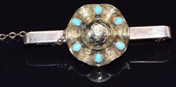 A 9ct gold brooch in the form of a hat set with turquoise cabochons and engraved decoration, 5g